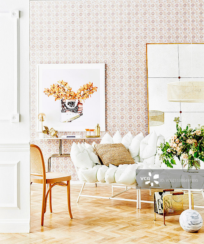 白色靠垫沙发放在镶木地板上，靠在贴壁纸的墙上图片素材