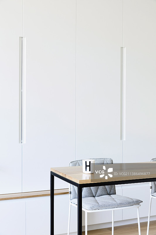 木制桌子与黑色金属框架在朴素的白色墙壁单元图片素材