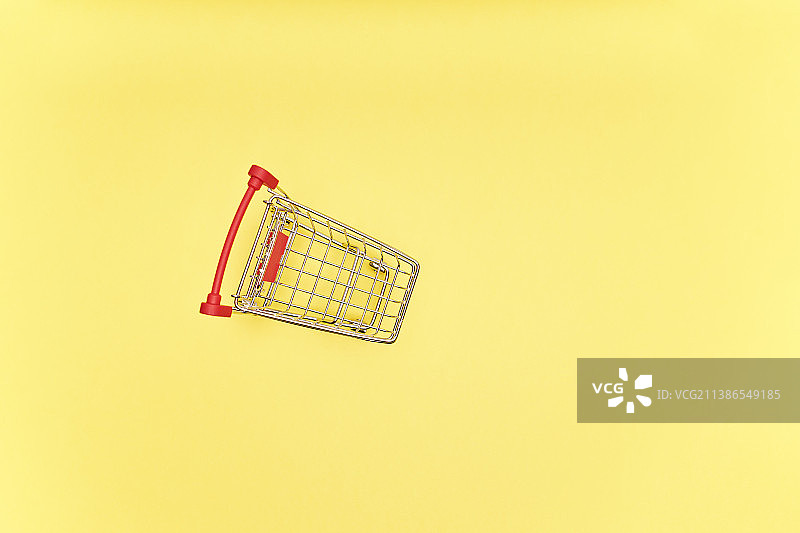 黄色背景的空红色购物车西班牙的食品购物概念图片素材