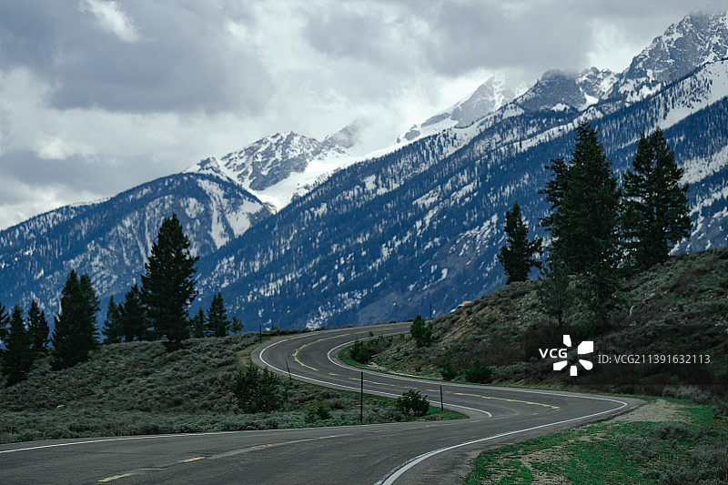 空旷的道路通向白雪皑皑的山峰，大提顿国家公园，怀俄明州，美国，美国图片素材