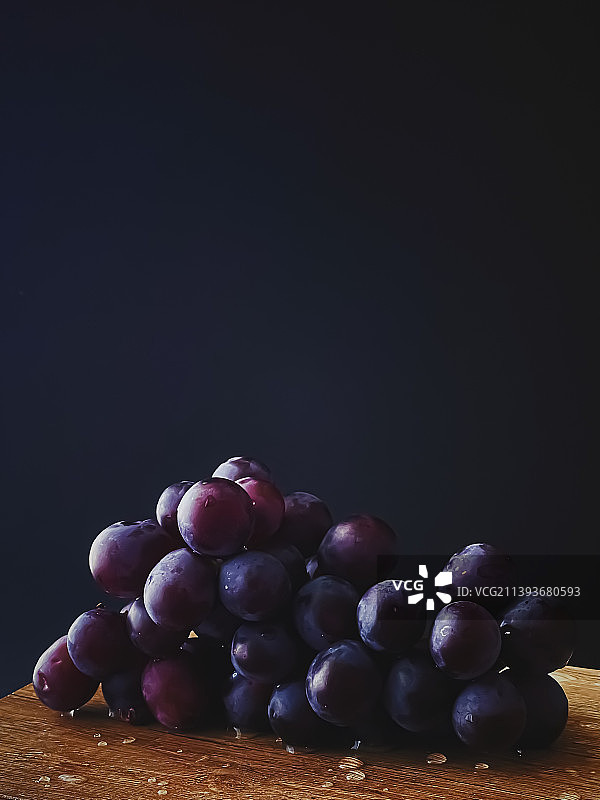 成熟多汁的黑葡萄在木制书桌，食物和酒，有机水果图片素材