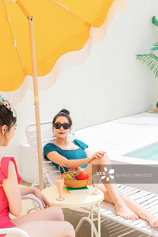 与朋友的暑假旅行概念系列_韩国美丽的亚洲年轻女性在日光浴床上休息图片素材