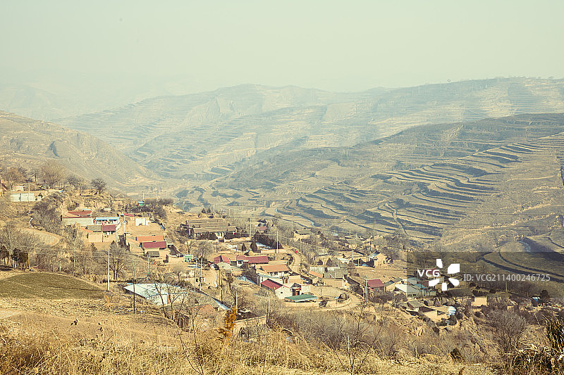 冬季枯黄的黄土高原上山坡上的田地与村庄图片素材