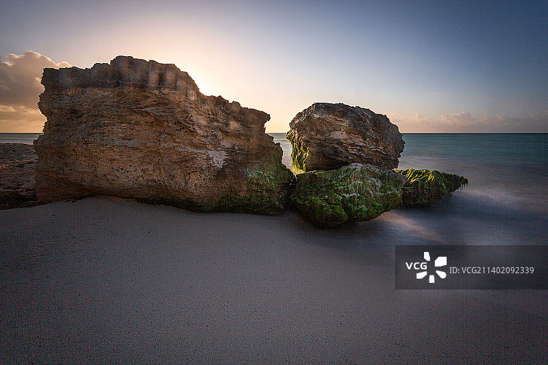 墨西哥金塔纳罗奥的卡门海滩，日落时海上岩石映衬天空的风景图片素材
