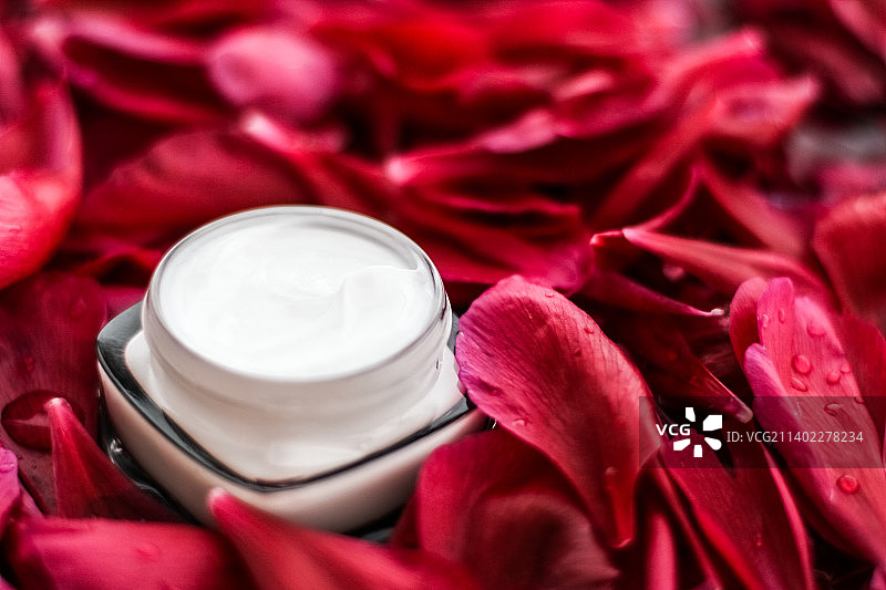 敏感护肤保湿霜在红色花瓣和水图片素材