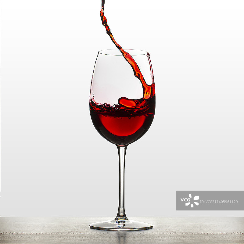 洒在酒杯里的红葡萄酒图片素材