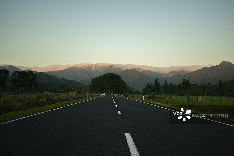 新西兰科罗曼德尔，空旷的道路沿着晴朗的天空图片素材
