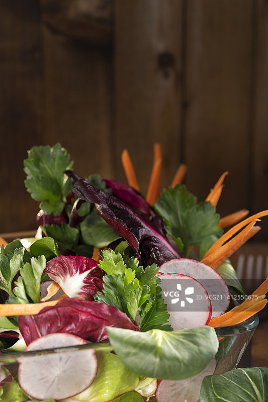 新鲜混合蔬菜沙拉与橄榄油敷料在乡村棕色图片素材