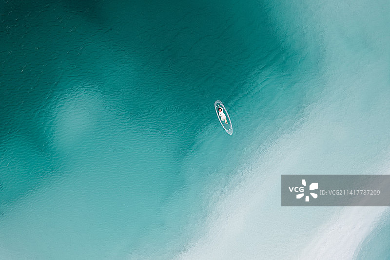 在中国青海大柴旦翡翠湖,在透明“玻璃船”上的的女性游客 航拍视角图片素材