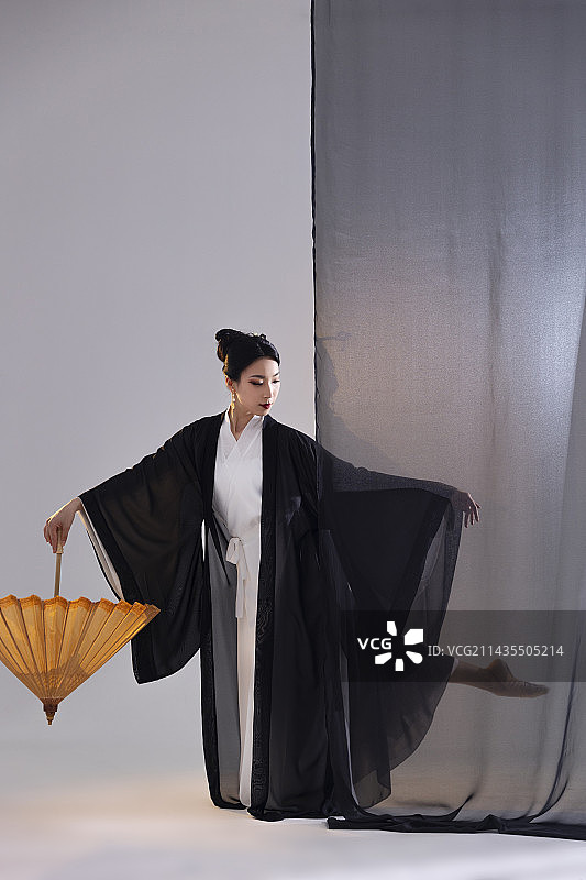 中国水墨油纸伞古典舞：古装美女舞者、油纸伞与黑色薄纱图片素材