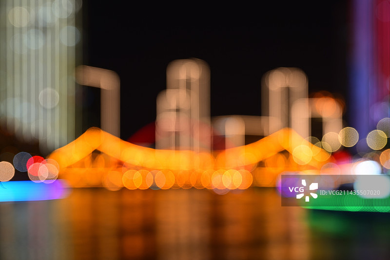 天津海河畔城市地标建筑绚丽多彩的模糊夜景灯光图片素材