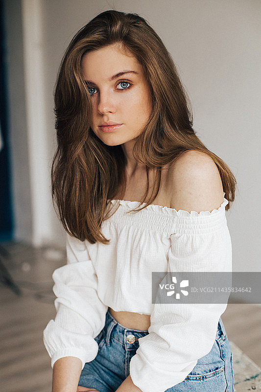 俄罗斯，一个年轻女孩在照相馆里，穿着白衬衫和蓝色牛仔裤图片素材