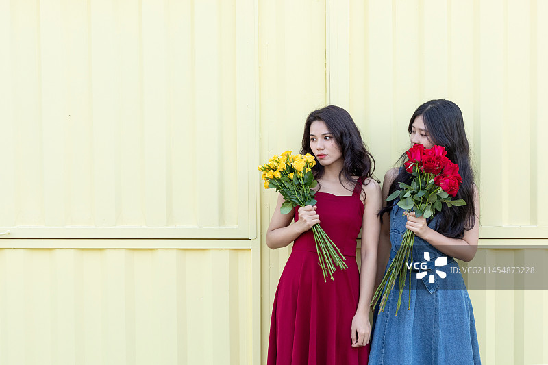 户外两名中国美女手拿着玫瑰花图片素材