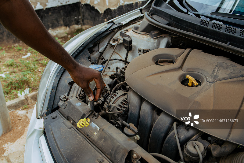 加纳，阿克拉，修理汽车发动机的人剪短了双手图片素材