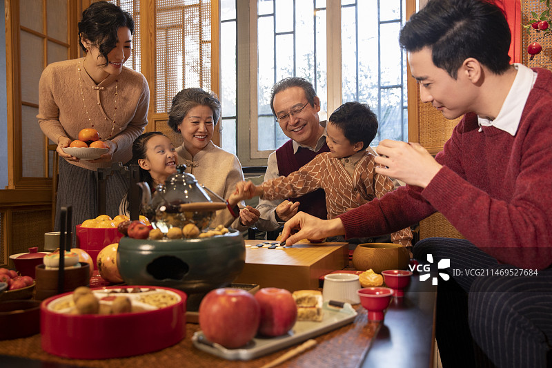 东方家庭过年：幸福一家人在客厅玩围棋、聊天嬉戏图片素材