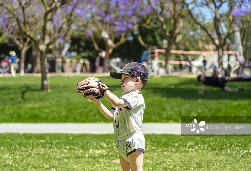 公园草坪上的儿童垒球运动员图片素材
