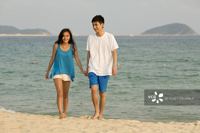 青年情侣在海边散步图片素材