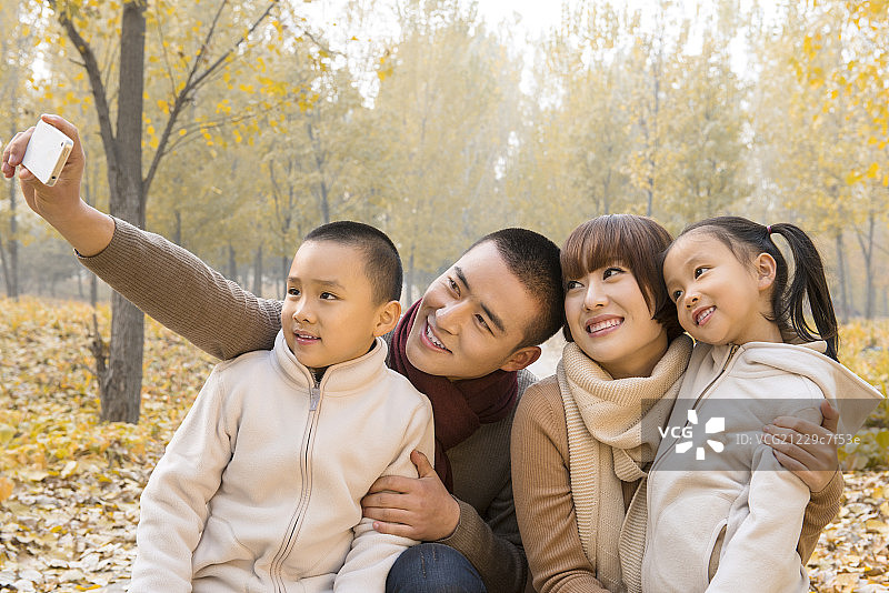 Family with two children at park taking selfie图片素材