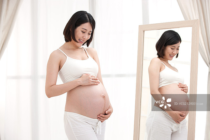 孕妇站在镜子前面图片素材