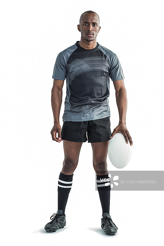 运动员的肖像拿着橄榄球，而站在白色的背景图片素材