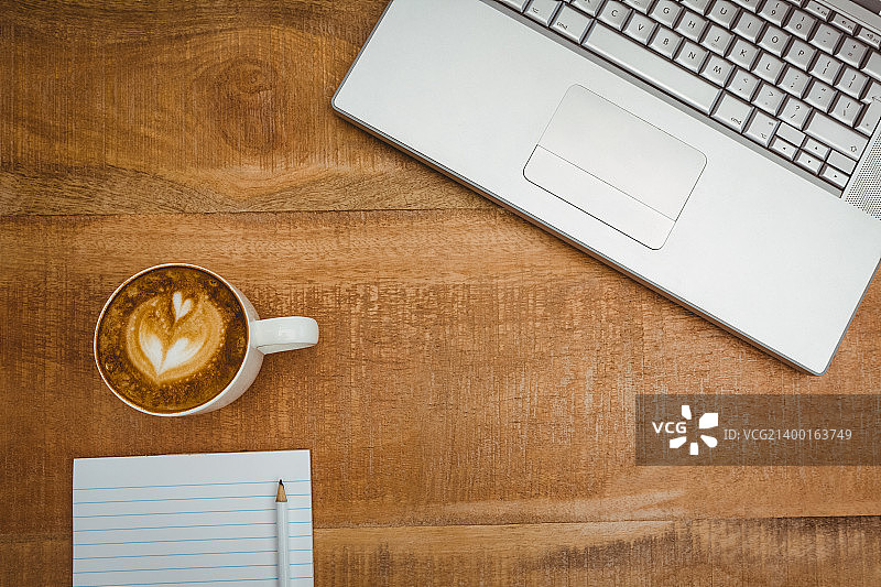 上图是一台笔记本电脑和一个咖啡壶图片素材