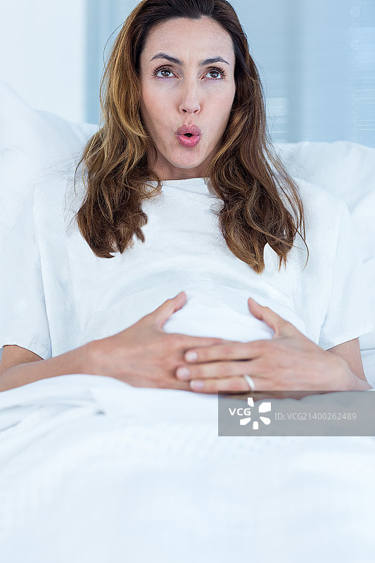 一个孕妇躺在病房的病床上图片素材