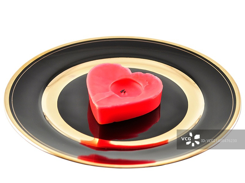 白色背景上的黑色盘子上的红心蜡烛图片素材