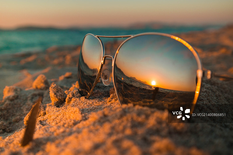 日落时在海滩上戴墨镜。图片素材