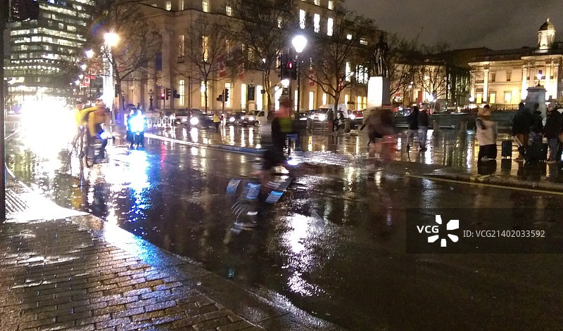 一个阴雨的夜晚，在特拉法加广场骑自行车上下班图片素材