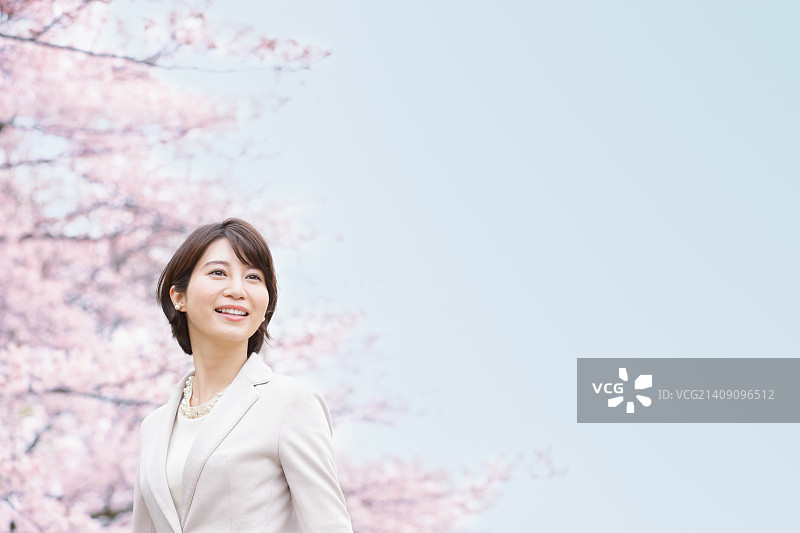 一个在城市公园里开着樱花的日本女人图片素材