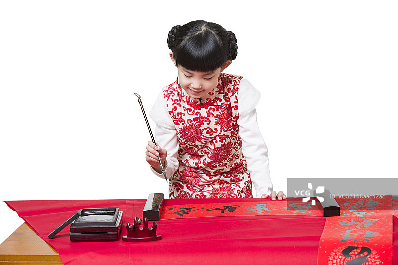 快乐的小女孩用毛笔写春节对联图片素材