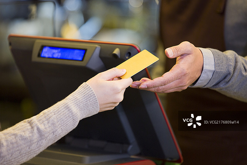 顾客在咖啡店用信用卡结账图片素材