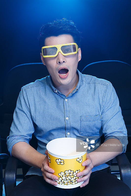 一个青年男人在电影院看电影图片素材