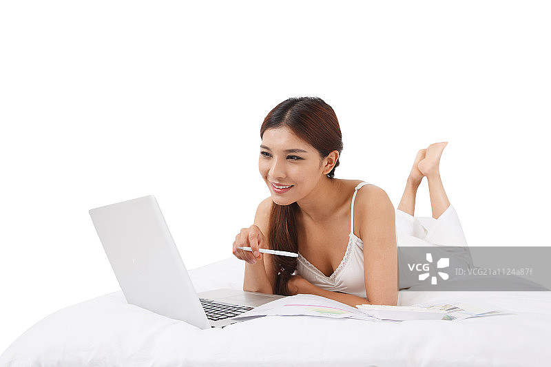 在床上玩电脑的青年女人图片素材
