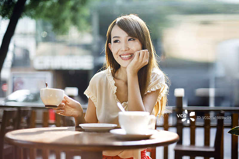 年轻女性在露天咖啡厅喝咖啡图片素材