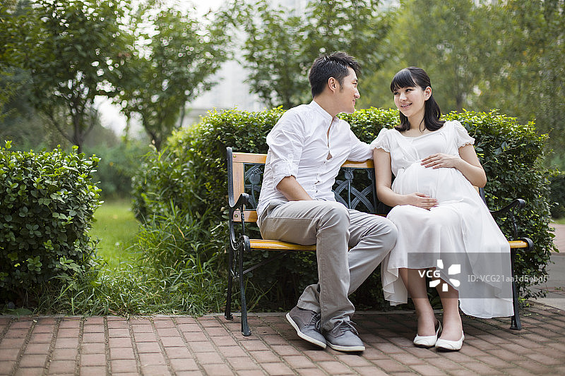 孕妇和丈夫坐在长椅上图片素材