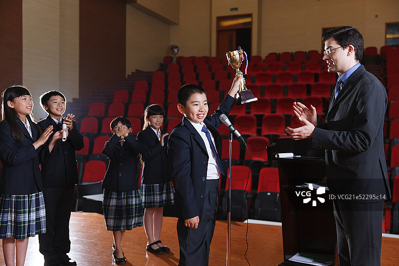 国际小学里的老师和小学生在颁奖台上图片素材