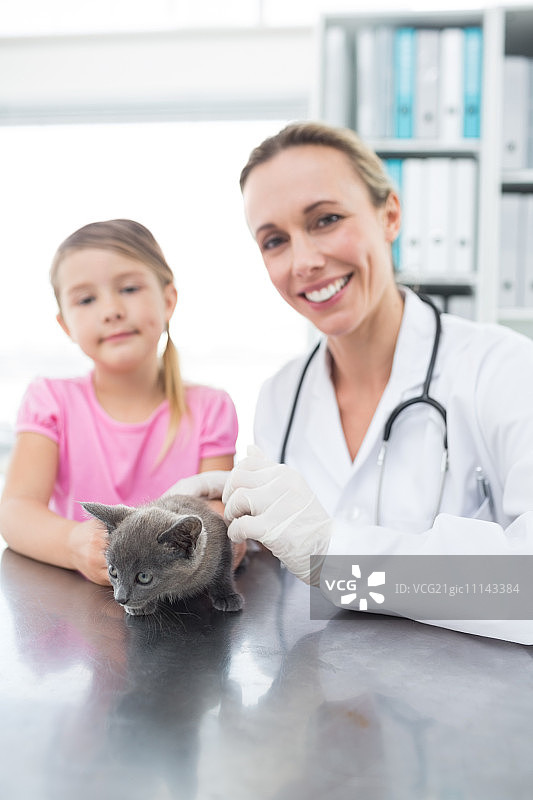 女兽医和女孩与小猫在诊所的肖像图片素材