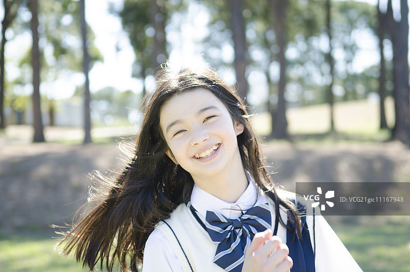 穿着校服的少女，脸上挂着灿烂的笑容图片素材