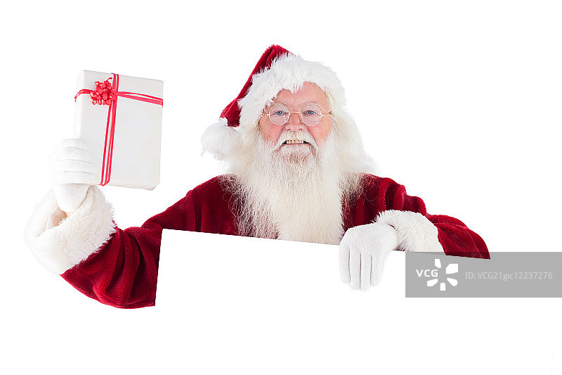 圣诞老人拿着白色背景上的标志展示礼物图片素材