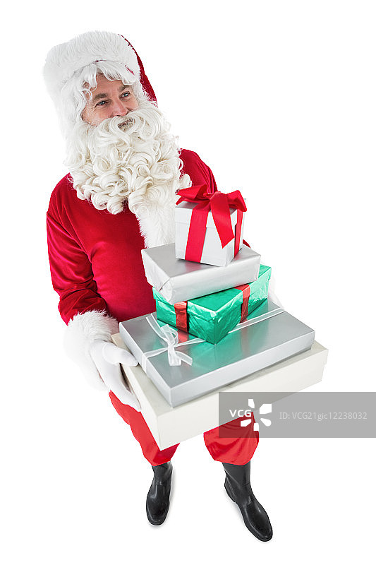 快乐的圣诞老人拿着一堆礼物在白色的背景图片素材