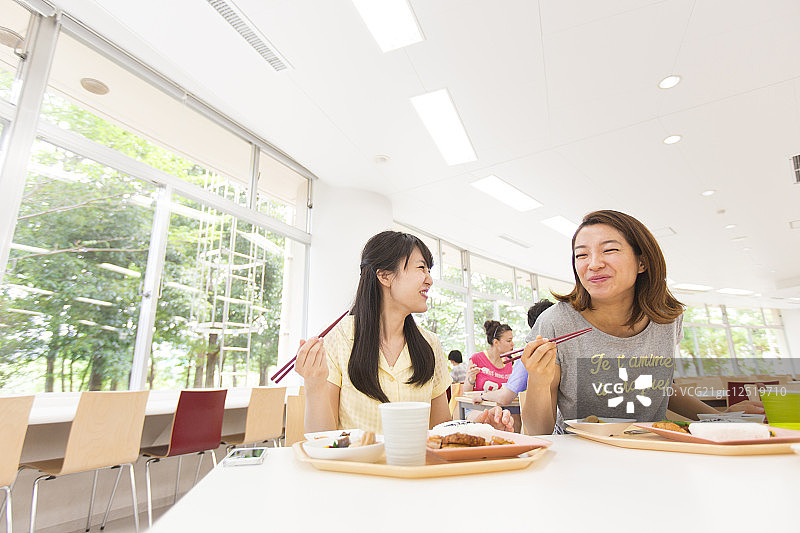 微笑的大学生在自助餐厅吃午饭图片素材