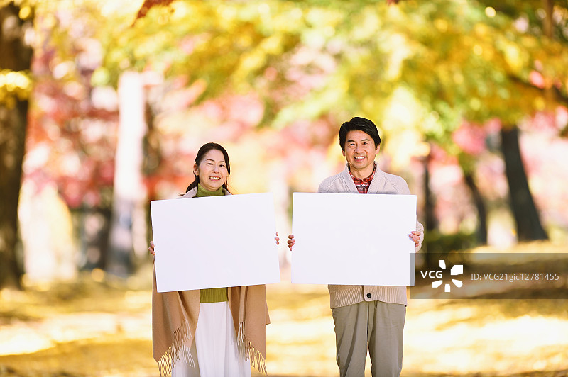 一对日本老年夫妇在城市公园里拿着白板图片素材