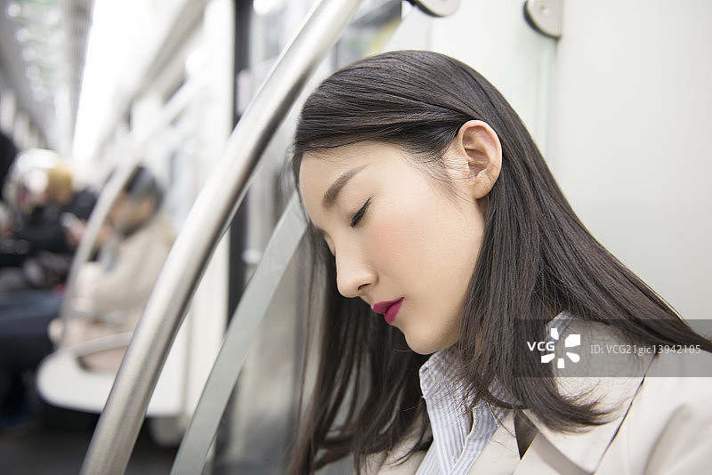 Businesswoman falling asleep in subway图片素材
