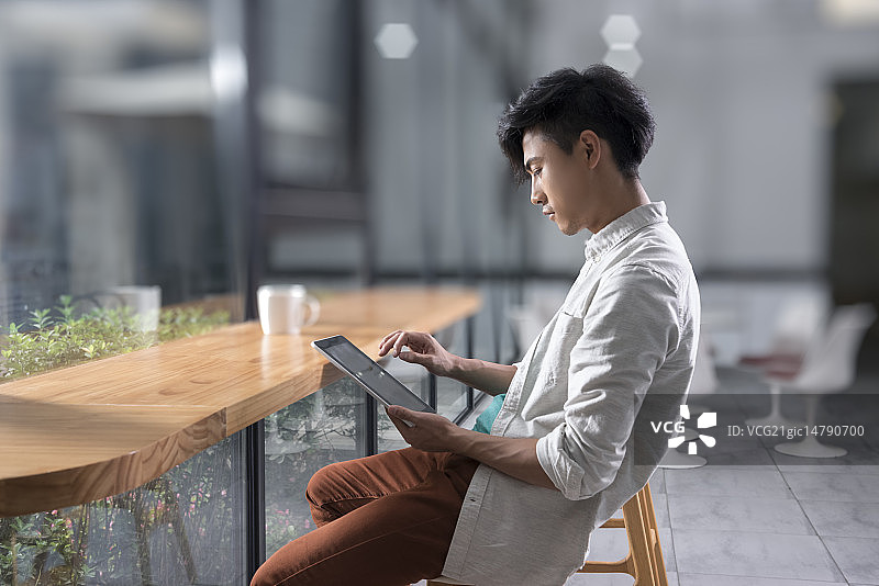 Creative businessman using digital tablet in break room图片素材