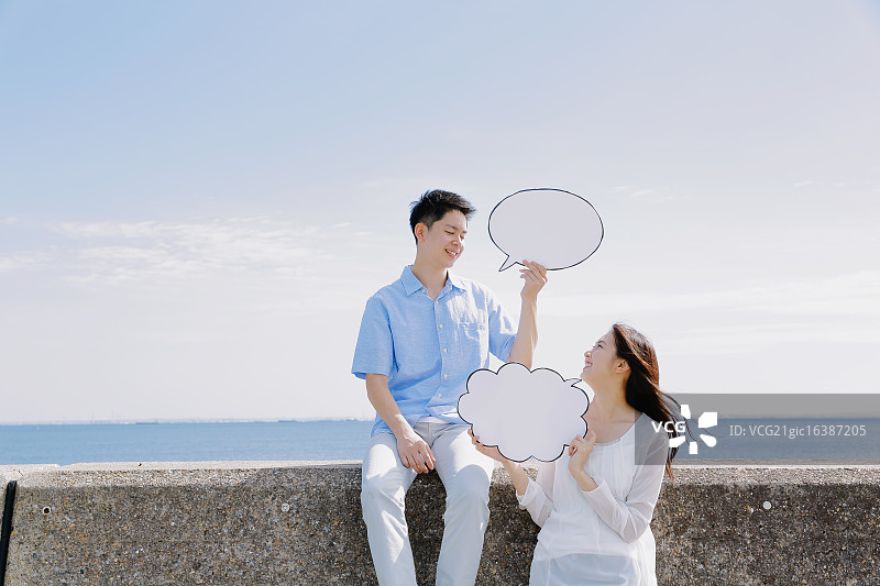 年轻的日本夫妇在海边留言板上留言图片素材
