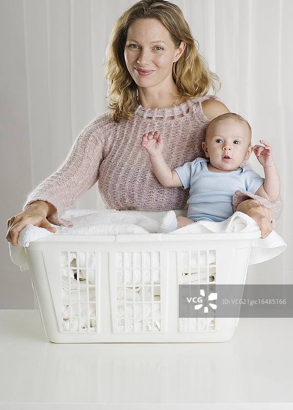 妈妈在洗衣篮里抱着婴儿图片素材