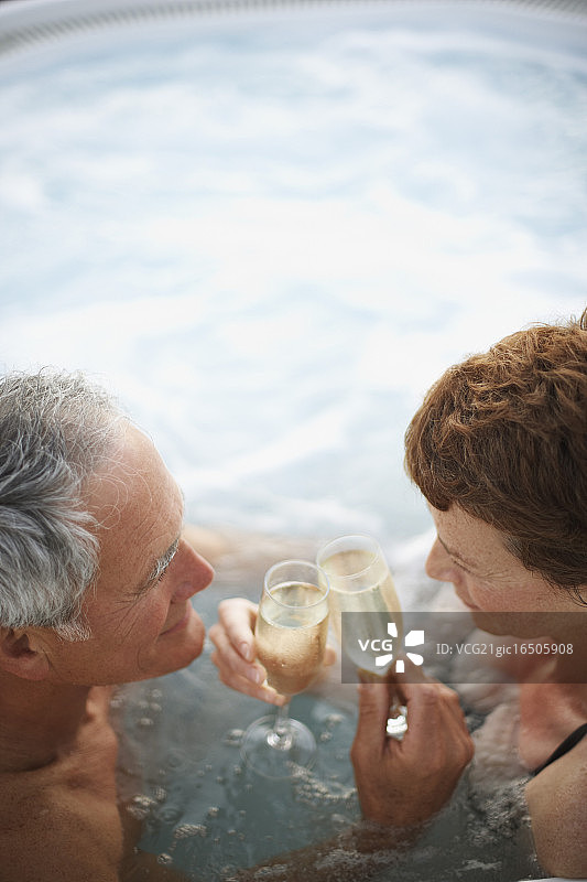 一对夫妇在热浴盆里用香槟祝酒图片素材
