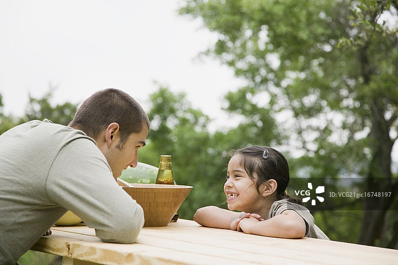 父亲和女儿坐在野餐桌上图片素材