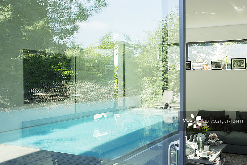 游泳池映在现代住宅的玻璃窗上图片素材